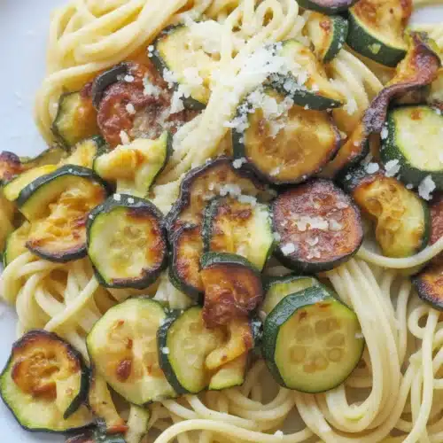 A vibrant dish of zucchini and pasta, featuring garlic, lemon, and Parmesan for added flavor.