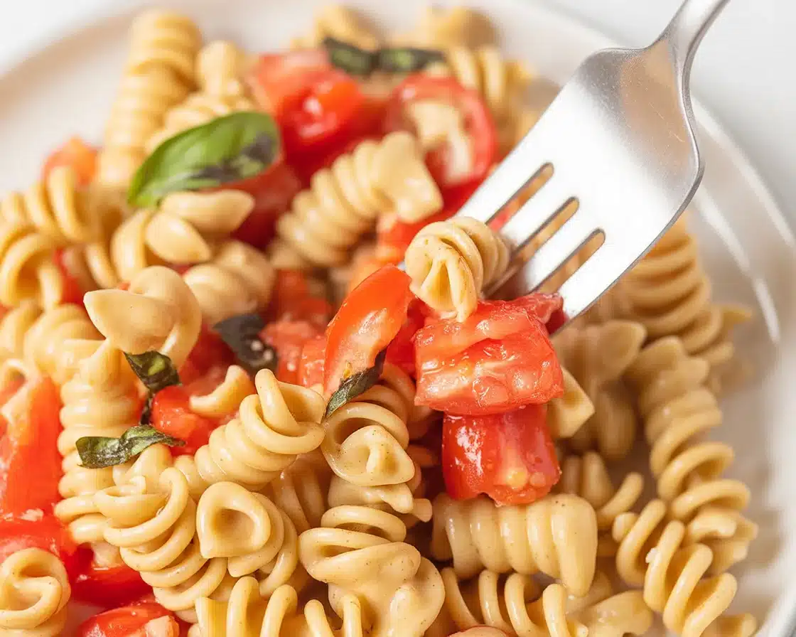 Fresh Tomato Pasta with garlic and basil, showcasing vibrant seasonal ingredients.